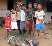 The youth group members happily clean up their village before making their recycled models.
