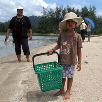 Hareem, Andaman Discoveries' Community Centre Manager's (Pinky), son helping the eco tourists learn about subsistence fishing practices. 