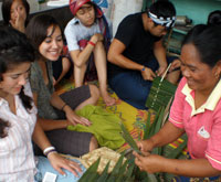 Students learning about Nipa palm weaving, one of Ban Talae Nok's sustainable livelihoods.