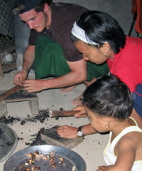 Jarad helps with cashew nut roasting in Tung Nang Dam